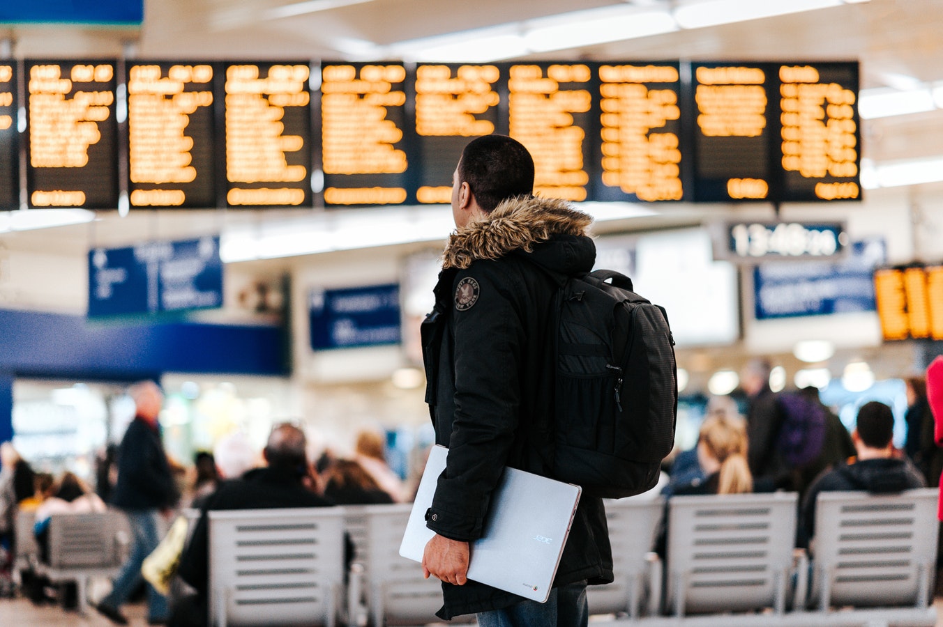 Man in airport with baggage and laptop